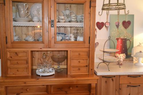 a wooden hutch with dishes in it in a kitchen at Vakantie Accommodatie Egelantier in Dwingeloo