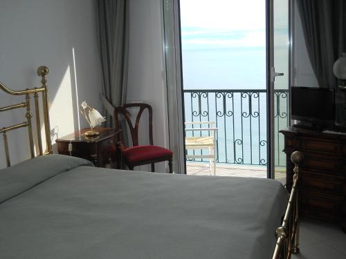 a bedroom with a bed and a balcony with a television at Hotel Leopold in Moneglia