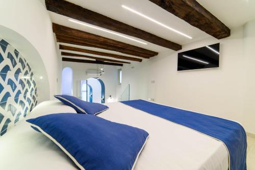 a bedroom with a large bed with blue pillows at Dimora Bertella boutique & SpA in Amalfi