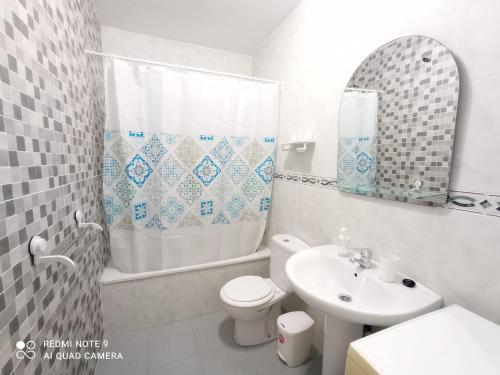 La salle de bains est pourvue d'un lavabo, de toilettes et d'un miroir. dans l'établissement Peñoncillo Beach, à Torrox Costa