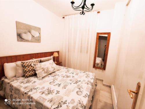 - une petite chambre avec un lit et un miroir dans l'établissement Peñoncillo Beach, à Torrox Costa