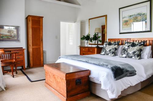a bedroom with a large bed with a wooden headboard at The Knoll Historic Guest Farm in Hilton