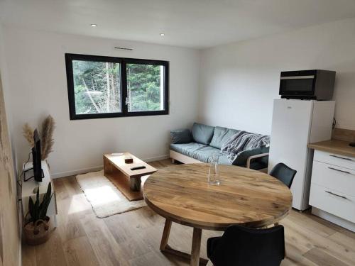 un soggiorno con un tavolo e un divano di Studio neuf proche centre-ville a Pabu