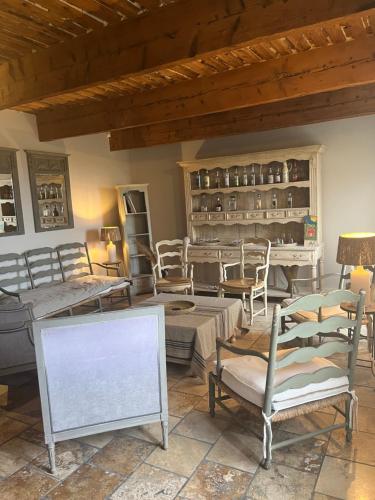 ein Wohnzimmer mit Stühlen, Tischen und einem Tisch in der Unterkunft Maison Bournissac in Noves