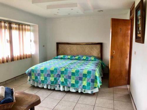 a bedroom with a bed with a colorful bedspread at Casa Real Palo Gacho in Emiliano Zapata