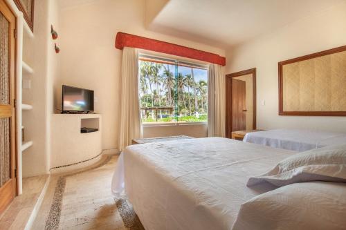 a hotel room with two beds and a window at Villas San Vicente in Acapulco