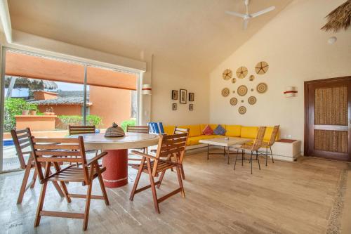a living room with a table and chairs and a couch at Villas San Vicente in Acapulco