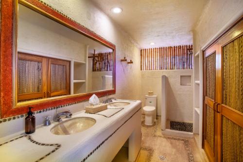 a bathroom with a sink and a mirror and a toilet at Villas San Vicente in Acapulco