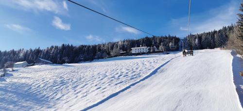 a group of people skiing down a snow covered slope at Alpengasthof Fernblick in Mönichkirchen