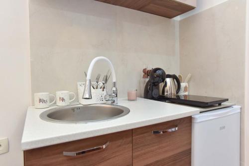 a bathroom with a sink and a counter with cups at Beach House in Petrovac na Moru