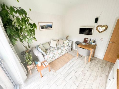 a living room with a couch and a table at Tern Cottage in Groomsport