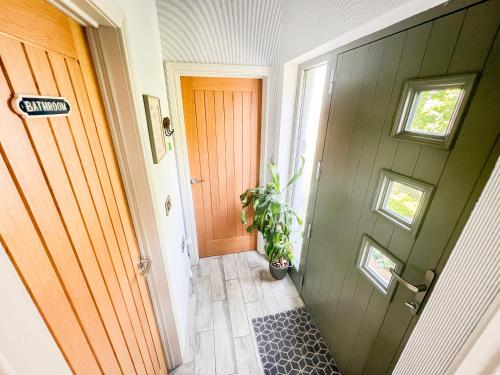a hallway with a door and a potted plant at Tern Cottage in Groomsport