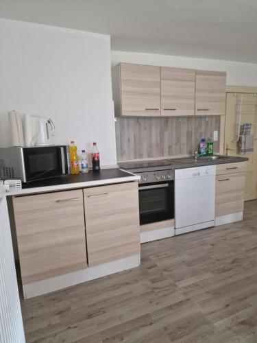 una cocina con electrodomésticos blancos y armarios de madera en Ferienhaus Kallmeyer, en Parey