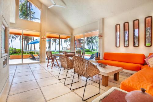 a living room with an orange couch and chairs at Villas San Vicente in Acapulco