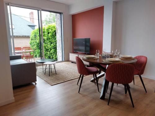 uma sala de jantar com uma mesa e cadeiras e uma televisão em La Villa Bompard*** 50m² Cœur de ville avec terrasse em Rodez