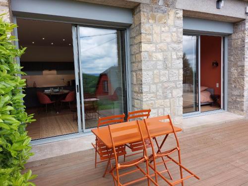 une table et des chaises en bois sur une terrasse en bois dans l'établissement La Villa Bompard*** 50m² Cœur de ville avec terrasse, à Rodez