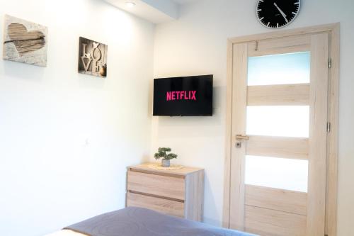 a bedroom with a door and a clock on the wall at Konik Morski in Jastarnia