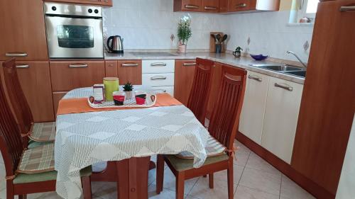 uma cozinha com uma mesa com 2 cadeiras e um lavatório em Apartment Olea em Kastav