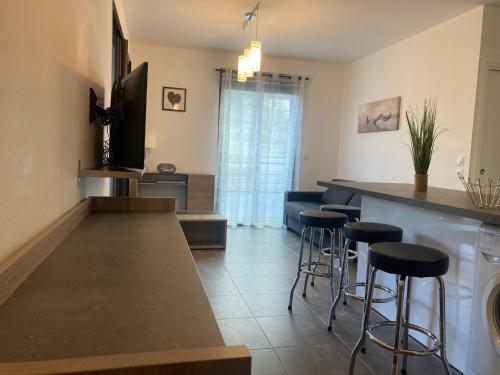 une cuisine avec un comptoir et des tabourets de bar dans l'établissement T2 standing Ajaccio, à Ajaccio