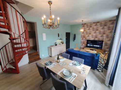 une salle à manger et un salon avec une table et des chaises dans l'établissement Le TROPICA Appartement 2 chambres, plein Sud centre ville de VITRÉ, à Vitré