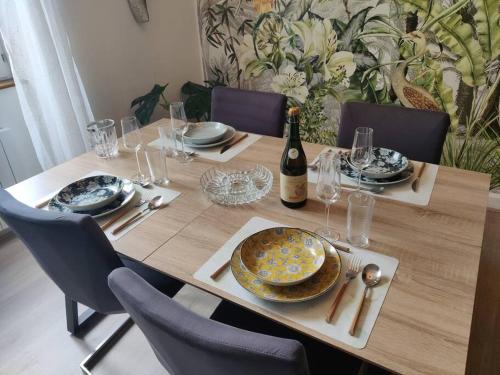 a table with a bottle of wine and a plate of food at Le TROPICA Appartement 2 chambres, plein Sud centre ville de VITRÉ in Vitré