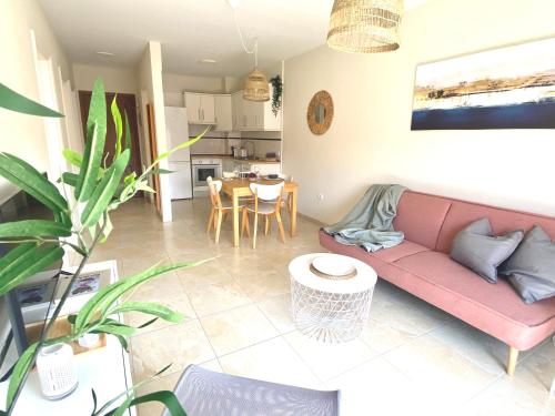 un soggiorno con divano rosa e tavolo di Casa Isa - Aire acondicionado - Piscina - Candelaria - Tenerife a Candelaria