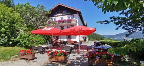 a building with tables and umbrellas in front of it at Alpengasthof Fernblick in Mönichkirchen