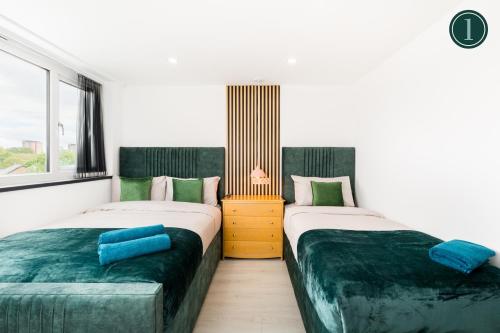 two beds sitting next to each other in a room at Birmingham Central Deluxe Inn in Birmingham