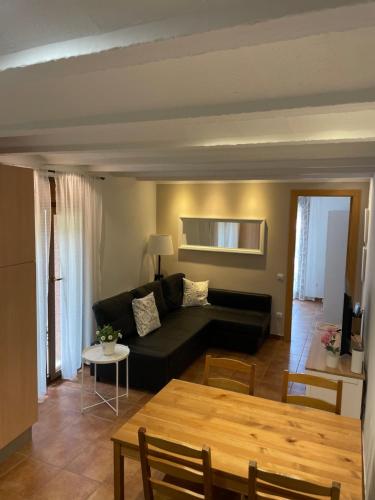 a living room with a black couch and a table at Apartamento vacacional in El Pont de Suert