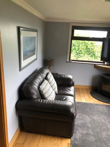 a leather couch in a living room with a window at NEWCASTLE STUNNING SEA VIEW apartment absolute top quality over 500 of 5 star reviews You will not be disappointed in Widows Row