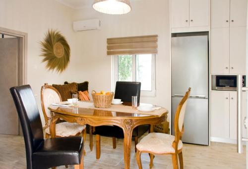a dining room with a wooden table and chairs at Sia's Sea House in Almirida