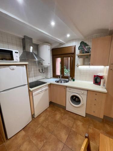 a kitchen with a white refrigerator and a dishwasher at Apartamento vacacional in El Pont de Suert