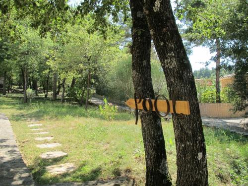 a wooden object is attached to a tree at LA VILLA DU PETIT BOIS Les Lavandes in Faucon