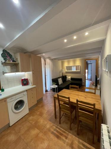 a kitchen and living room with a wooden table and chairs at Apartamento vacacional in El Pont de Suert