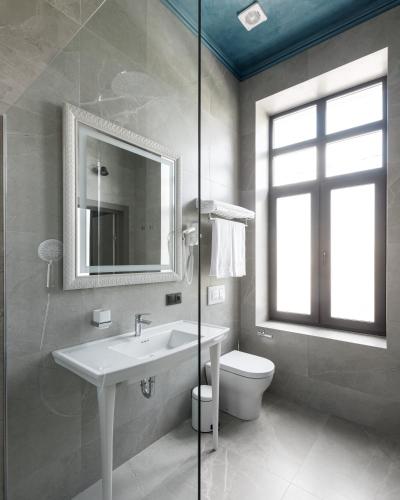 a bathroom with a sink and a toilet and a mirror at Richmond Hotel in Chişinău