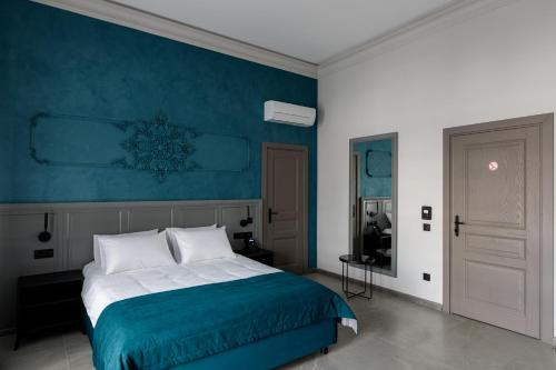 a bedroom with a bed with a blue wall at Richmond Hotel in Chişinău