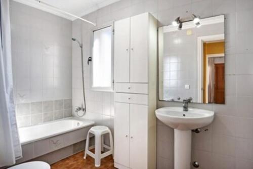 a white bathroom with a sink and a tub and a toilet at Casa con PATIO en el centro de la Ciudad in Chiclana de la Frontera