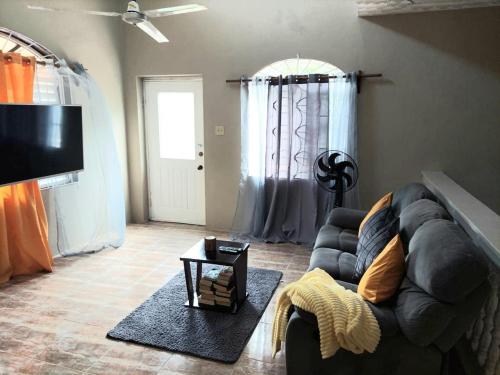 a living room with a couch and a flat screen tv at Cambridge mi casa ur casa with pool and beach access in Runaway Bay