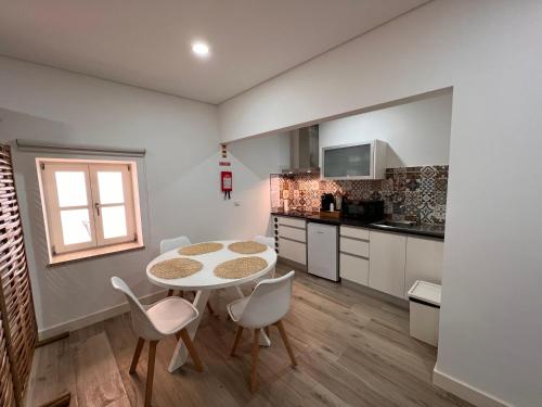 a kitchen with a table and chairs in a room at Pátio 29 - Guest House in Viana do Castelo