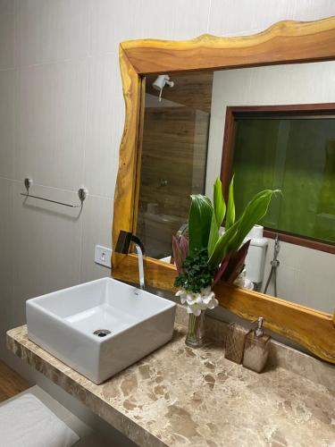 a bathroom with a white sink and a mirror at Pousada Águas de Tamandaré in Tamandaré