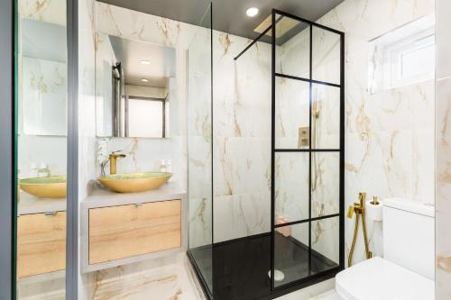 a bathroom with a glass shower and two sinks at Birmingham Central Deluxe Inn in Birmingham