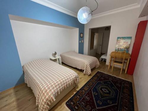 twee bedden in een kamer met blauwe en witte muren bij Bosphorus waterfront flat, Cengelköy in Istanbul