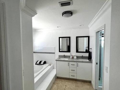 un bagno bianco con vasca, lavandino e vasca di Sunny Getaway: Relaxing Miami Home a Tamiami