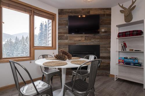 a dining room with a table and chairs and a fireplace at Iron Horse C3013 condo in Winter Park