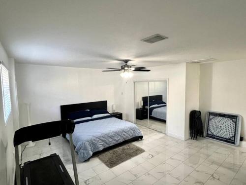 um quarto com uma cama e uma ventoinha de tecto em Sunny Getaway: Relaxing Miami Home em Tamiami