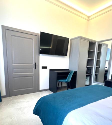 a bedroom with a bed and a desk and a tv at Richmond Hotel in Chişinău