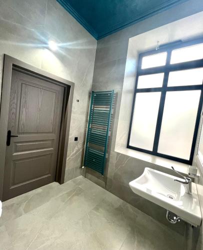 a bathroom with a sink and a window and a door at Richmond Hotel in Chişinău