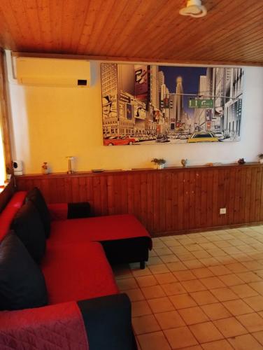 a living room with a red couch in front of a wall at INTERO APPARTAMENTO catania policlinico in Gravina di Catania