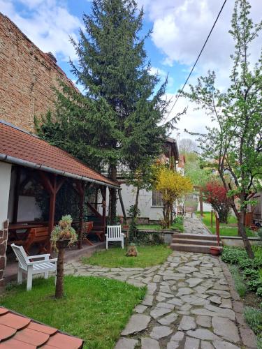 a garden with a stone walkway and a pavilion at 7 Levél Central Apartments in Miercurea-Ciuc
