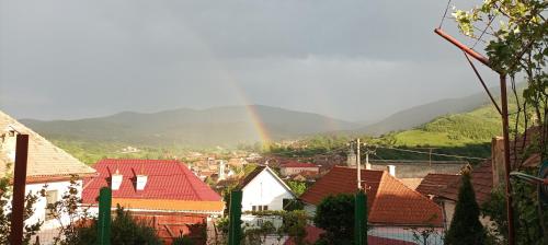 a rainbow over a city with houses and mountains at Apartament Panoramic la casa in comuna Rasinari in Răşinari